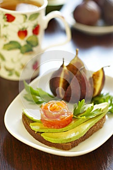 Sandwich with avocado and salmon and figs