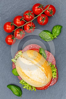 Sandwich baguette with salami ham portrait format from above slate