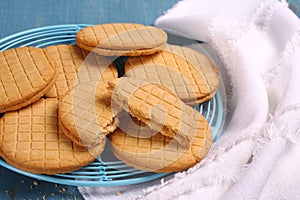 Sandwich biscuits with syrup filling on blue wooden background