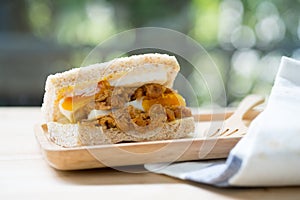 Sandwich with boiled egg on wooden tray