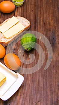 Sandwich ,bread and butter,eggs,lime,butter pancake on a wooden table with space for text,