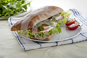 Sandwich with carob bread, ham and salad