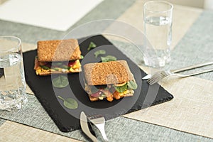 Sandwich with cereals bread and salmon on dark marble background