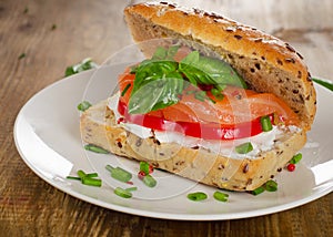 Sandwich with cereals bread and salmon on a old wooden table.