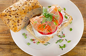 Sandwich with cereals bread and salmon on rustic wooden backgrou