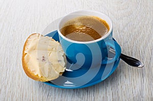 Sandwich with cheese, coffee in cup, spoon on saucer on table