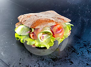 Sandwich with cheese, salad, sausage and vegetables