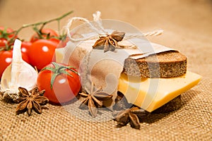 Sandwich with cheese wrapped in paper, cherry tomatoes and garli