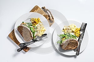 Sandwich with chicken breast, arugula, omelette and corn. White background. Top view