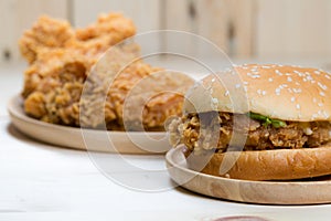 Sandwich with chicken burger on wooden plate.