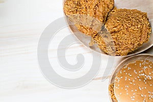 Sandwich with chicken burger on wooden plate. on top