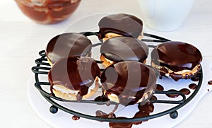 Sandwich cookies with chocolate ganache dripping on wire rack