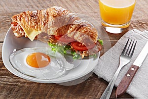 Sandwich croissant with fried bacon cheese tomato breakfast and egg