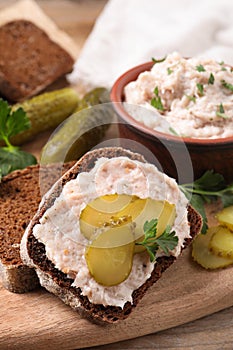 Sandwich with delicious lard spread and pickles on wooden table, closeup