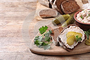 Sandwich with delicious lard spread and pickles on wooden table. Space for text