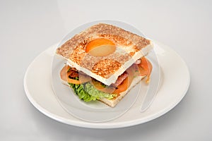 Sandwich with egg, bacon, tomato and cheese lettuce