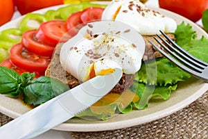 Sandwich with egg poached, lettuce, black bread with seeds, tomatoes, sweet pepper