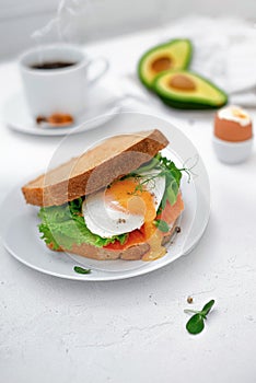 Sandwich with egg, smoked salmon, avocado and lettuce