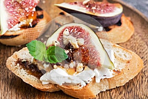 A sandwich with figs, cheese, nuts and honey. Selective focus, close-up.