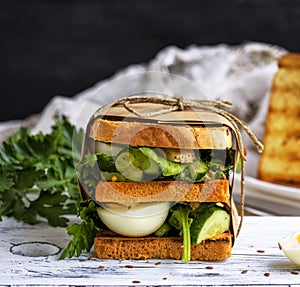 Sandwich of French toast and lettuce leaves and boiled egg