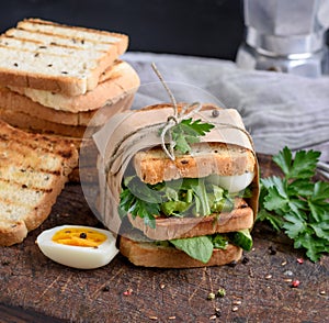 Sandwich of French toast and lettuce leaves and boiled egg