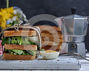 Sandwich of French toast and lettuce leaves and boiled egg