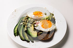 Sandwich with fresh vegetables, avocado, hard-boiled eggs and pumpkin seeds with olive oil and bread. healthy diet or