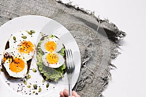 Sandwich with fresh vegetables, avocado, hard-boiled eggs and pumpkin seeds with olive oil and bread. healthy diet or