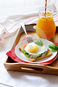 Sandwich with fried egg and orange juice