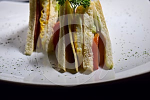 Sandwich with ham, cheese, tomatoes, lettuce, and toasted bread. Above view Vintage on Black background