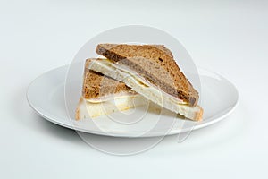 Sandwich with ham and cheese in white plate isolated. club sandwich with different bread closeup