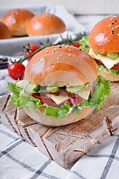 Sandwich with ham, cucumbers, tomatoes, lettuce leaves and cheese