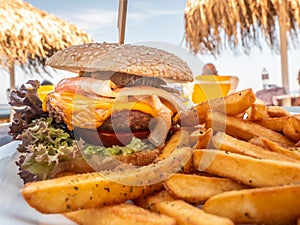 Sandwich with hamburger for lunch on beach