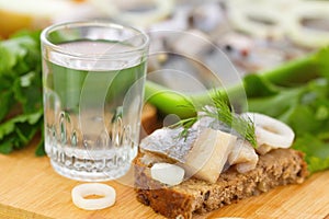 Sandwich with herring and glass of vodka