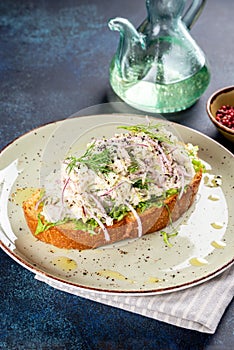 Sandwich with lingonberry and omul on a white round plate