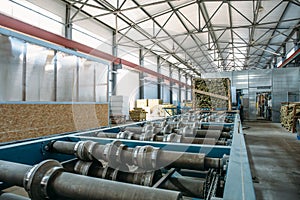 Sandwich manufactory panel production line. Equipment machine tools and roller conveyor in large hangar or workshop