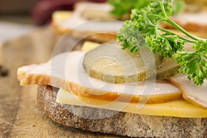 Sandwich with meat and chease on cutting board. Soft focus photo