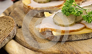 Sandwich with meat and chease on cutting board. Soft focus photo