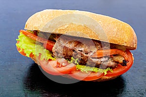 Sandwich: Meat rolls with vegetables in a bun with tomato and lettuce leaves