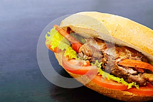 Sandwich: Meat rolls with vegetables in a bun with tomato and lettuce leaves