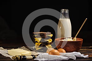 Sandwich, milk, eggs and rustic cottage cheese on a wooden background