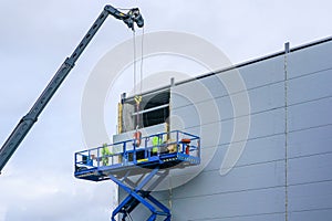 Sandwich panels wall mounting using crane and scissor lift