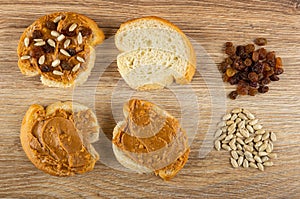 Sandwich with peanut pasta, bread, heap of sunflower seeds and raisin on table. Top view