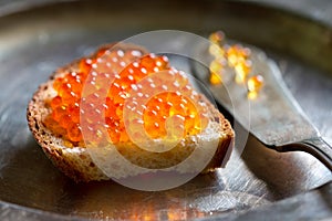 Sandwich with red caviar on old vintage retro plate still life