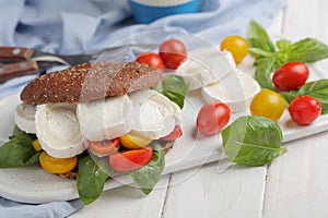 Sandwich with rye bread, goat cheese, tomatoes, and basil