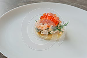 Sandwich with shrimps and caviar on white plate on dark stone table. Toast skagen - classic Swedish appetizer. Healthy food