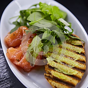 Sandwich with smoked salmon, cheese, tomatoes and herbs for healthy breakfast. close up