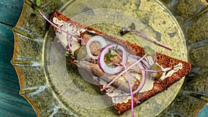 Sandwich with sprats and onion on an old metal tray. Danish cuisine. Food recipe background. Close up