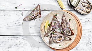 Sandwich with sprats on wooden table. Danish cuisine. banner, menu recipe place for text, top view