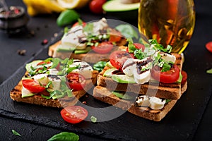 Sandwich toasts with tomatoes, mozzarella, avocado and basil